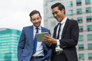 Two guys smiling looking at tablet